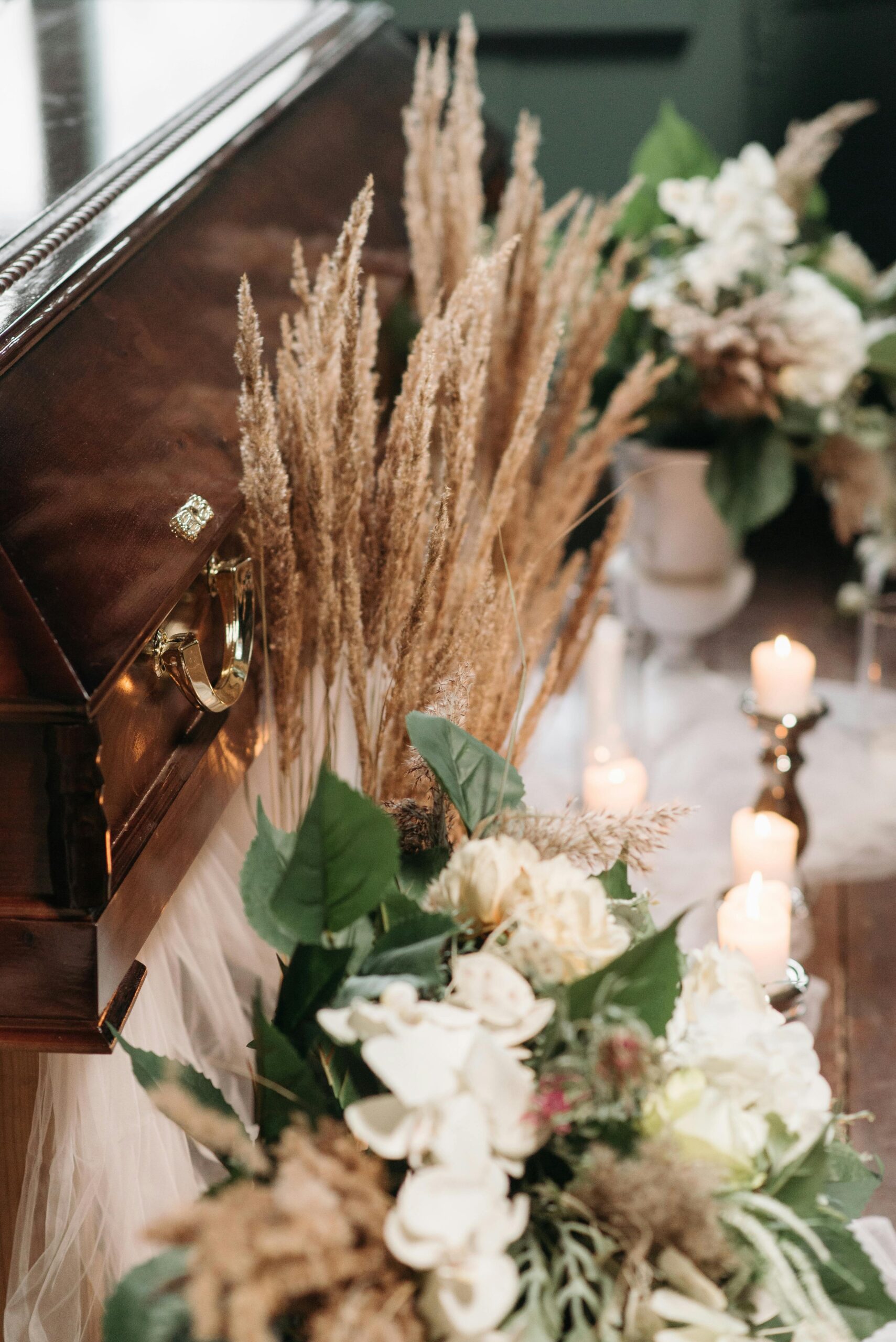 A serene funeral scene featuring a coffin surrounded by flowers and candles, emitting a respectful and peaceful atmosphere.